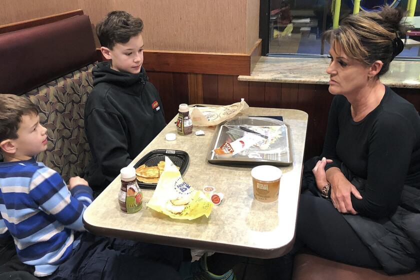 In this Jan. 10, 2019, photo, Tamra Cartwright, right, talks with sons Connor, 7, left, and Caden, 11, about the effect of multiple aftershocks from Alaska's recent magnitude 7.0 earthquake while interviewed in Anchorage, Alaska. Connor Cartwright says the aftershocks terrify him, and he fears his Anchorage home won't hold up. (AP Photo/Rachel D'Oro)