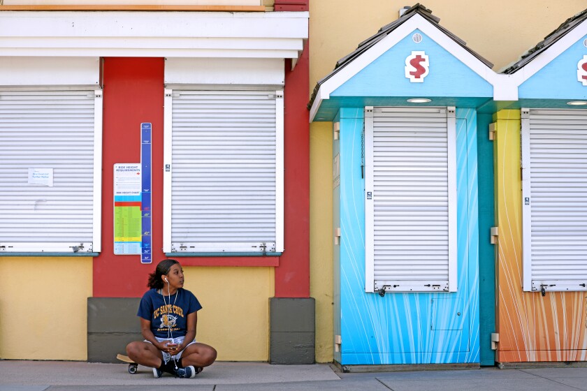 UC Santa Cruz student Brooklyn White talks on her phone at the closed Beach Boardwalk.