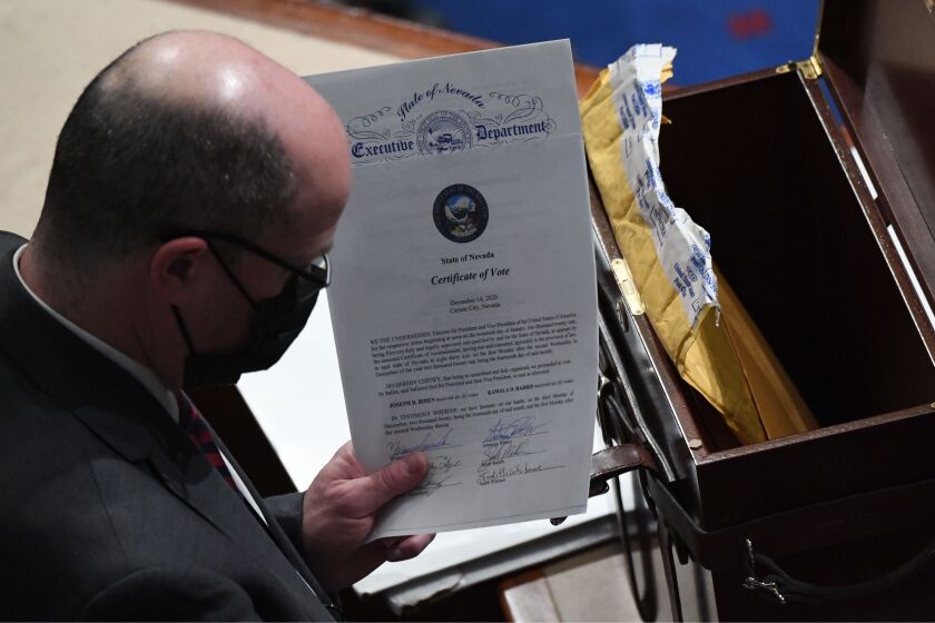 A man holds the certificate of vote from the state of Nevada during a joint session of Congress after the session resumed following protests at the US Capitol in Washington, DC, early on January 7, 2021. - Members of Congress returned to the House Chamber after being evacuated when protesters stormed the Capitol and disrupted a joint session to ratify President-elect Joe Biden's 306-232 Electoral College win over President Donald Trump. (Photo by SAUL LOEB / AFP) (Photo by SAUL LOEB/AFP via Getty Images)