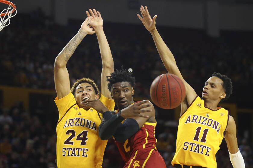 USC guard Jonah Mathews passes to a teammate after driving to the basket against Arizona State's Jalen Graham (24) and Alonzo Verge Jr. (11) during a game Feb. 8, 2020, in Tempe.