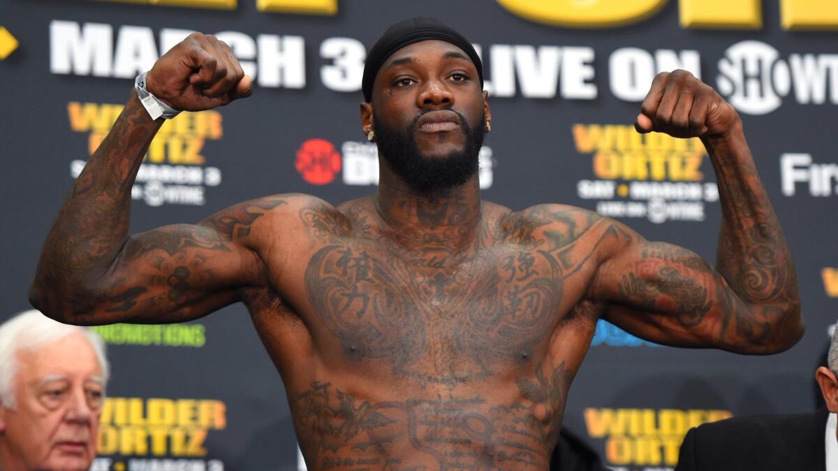 WBC heavyweight champion Deontay Wilder holds his arms up a weigh-in on March 2.