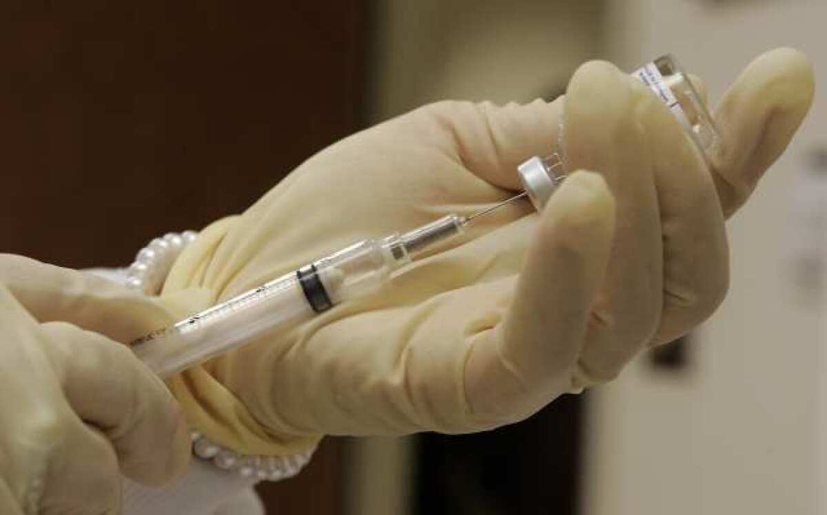 A syringe is filled with flu vaccine at a Pasadena clinic.