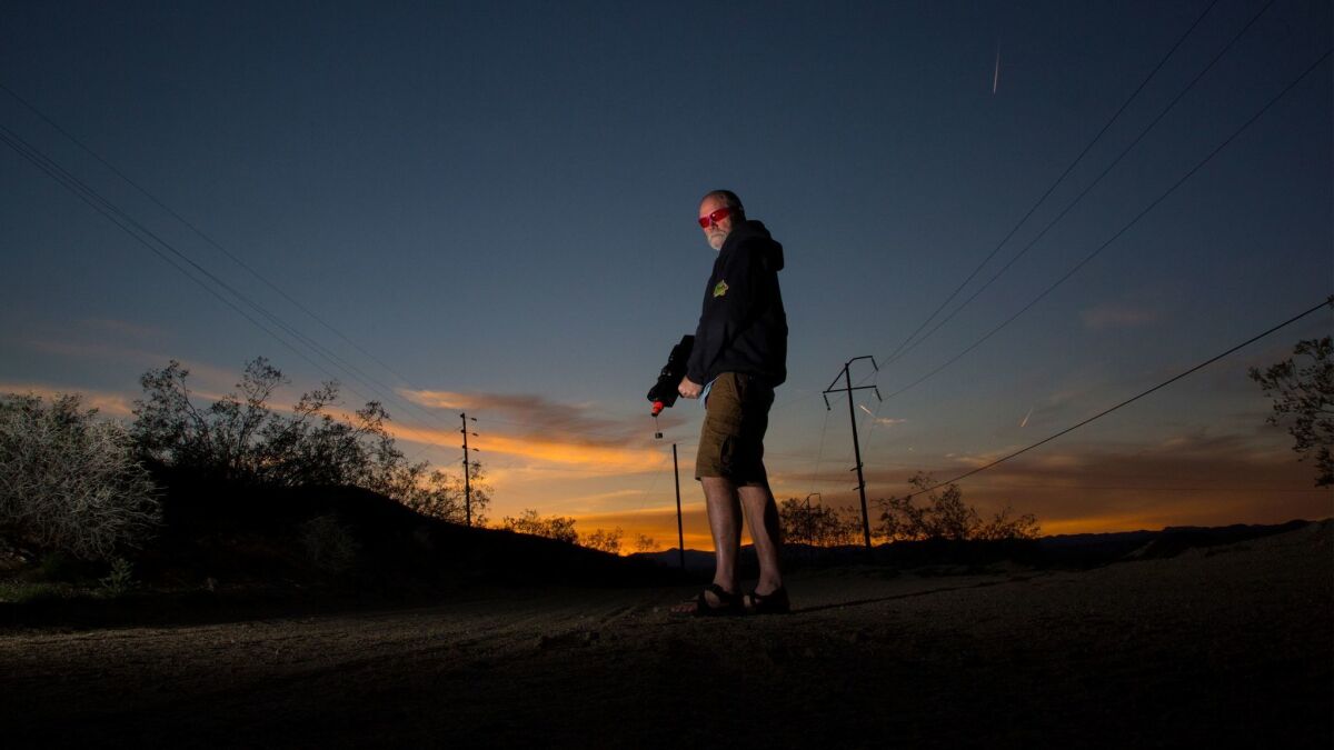 Biologist Tim Shields carries a nonlethal laser gun, which he uses to scare predatory ravens away from baby desert tortoises in Joshua Tree.