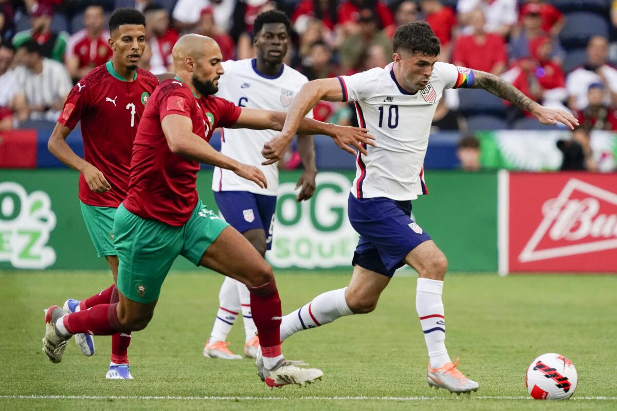 El delantero de Estados Unidos Christian Pulisic maneja el balón superando a Sofyan Amrabat de Marruecos en el juego amistoso el miércoles 1 de junio del 2022 en Cincinnati. (AP Foto/Jeff Dean)