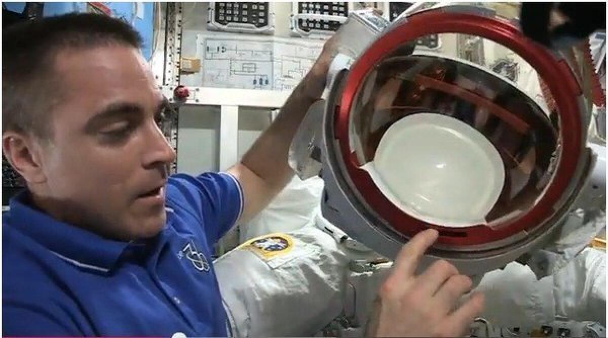 NASA astronaut Chris Cassidy explains the water leak in Italian astronaut Luca Parmitano's helmet during a spacewalk outside the International Space Station.