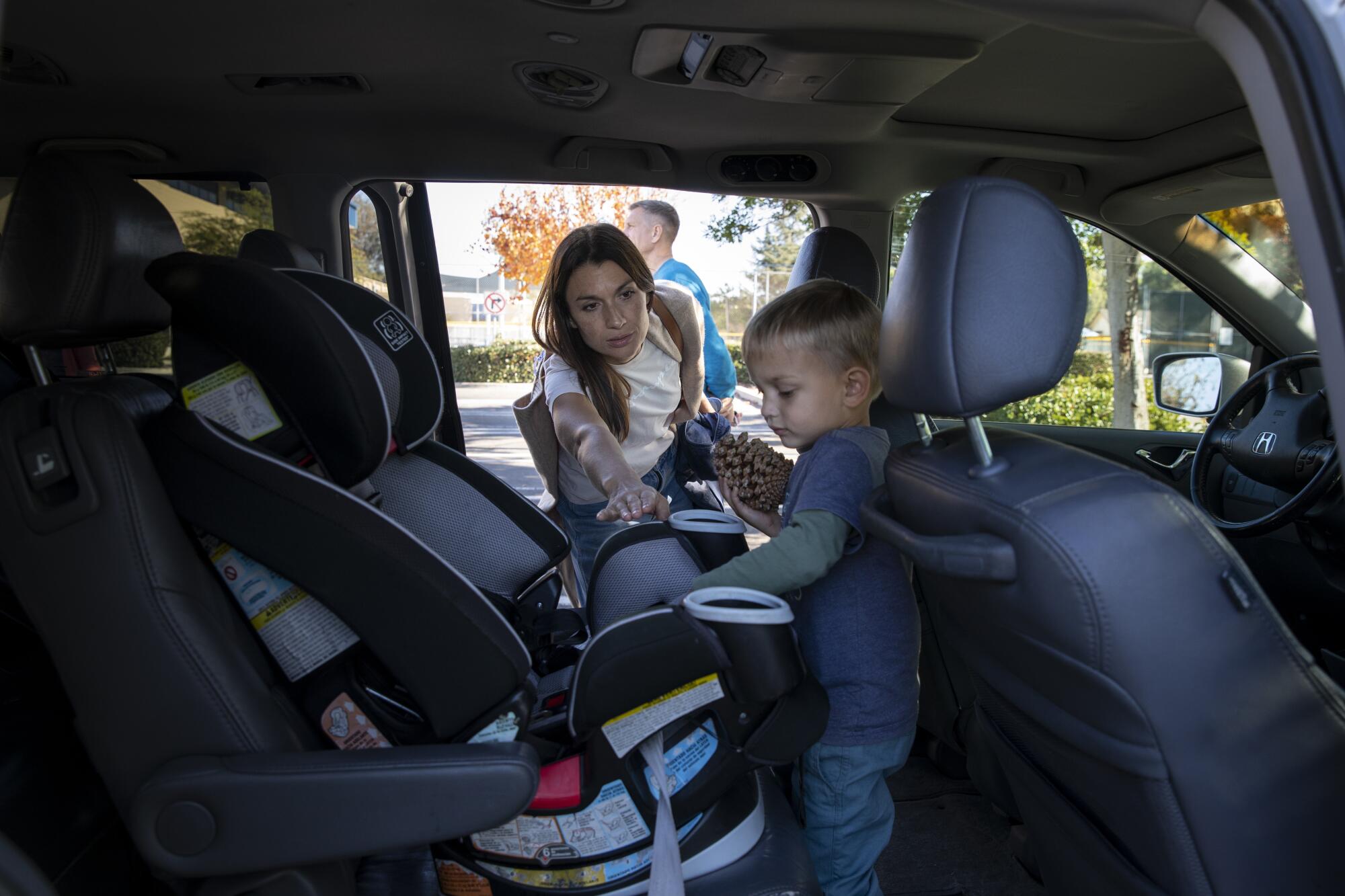 Anna Ermak puts her son Konstantin, 2, in a car seat