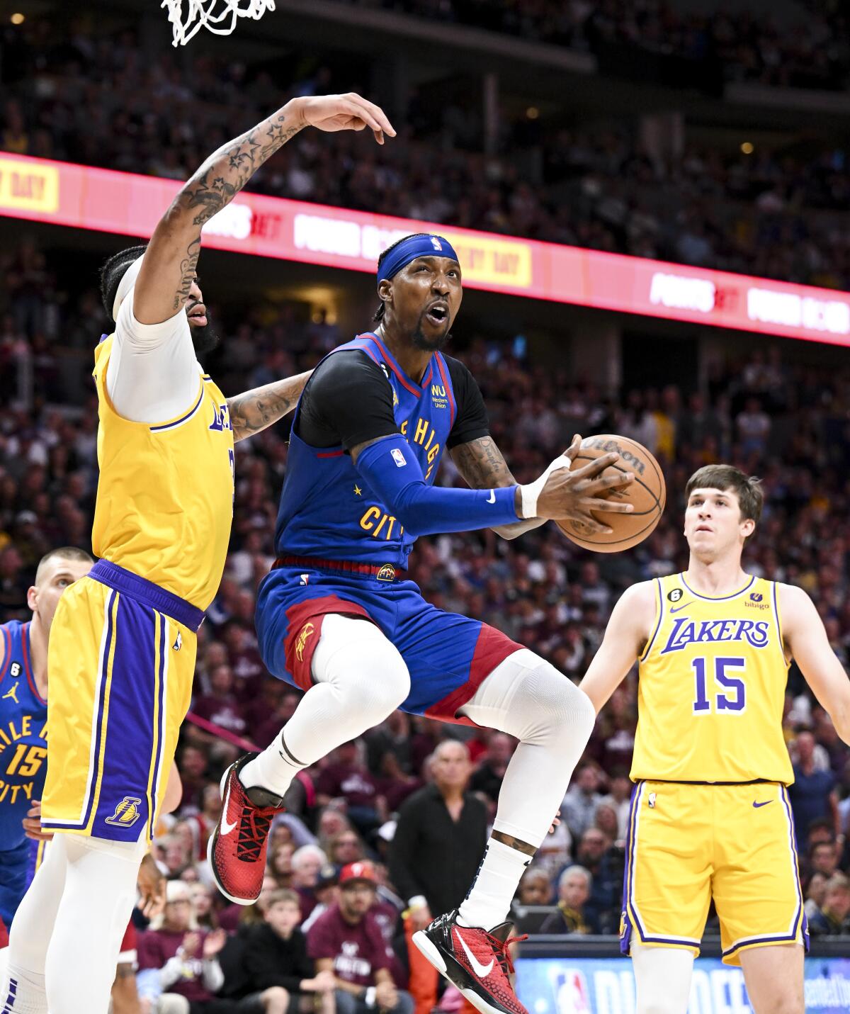 Nuggets guard Kentavious Caldwell-Pope, right, elevates for a shot while Lakers forward Anthony Davis looks to block the shot