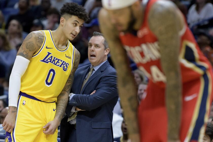 Lakers coach Frank Vogel talks to forward Kyle Kuzma (0) during a break in play Wednesday night in New Orleans.