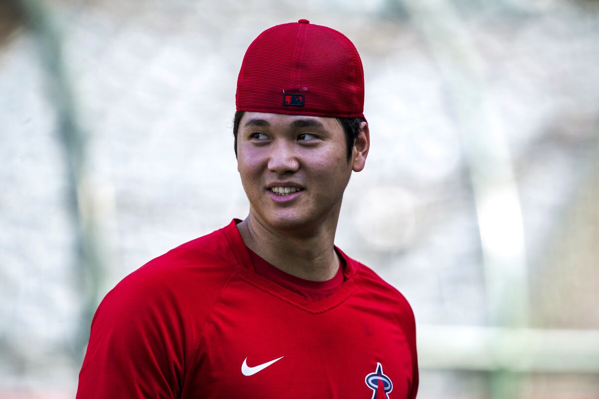 Shohei Ohtani walks on the field after warming up before Saturday's game against the Dodgers.