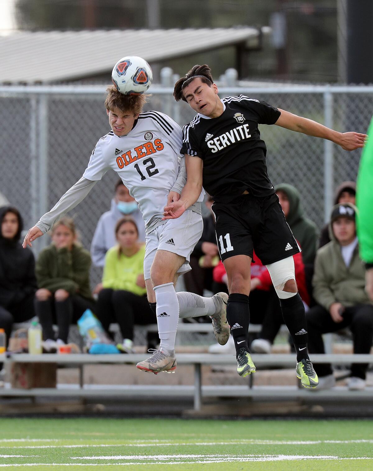 Huntington Beach's Bradley Kirkman (12) heads the ball against Servite's Kevin Sanchez (11) during the first half.