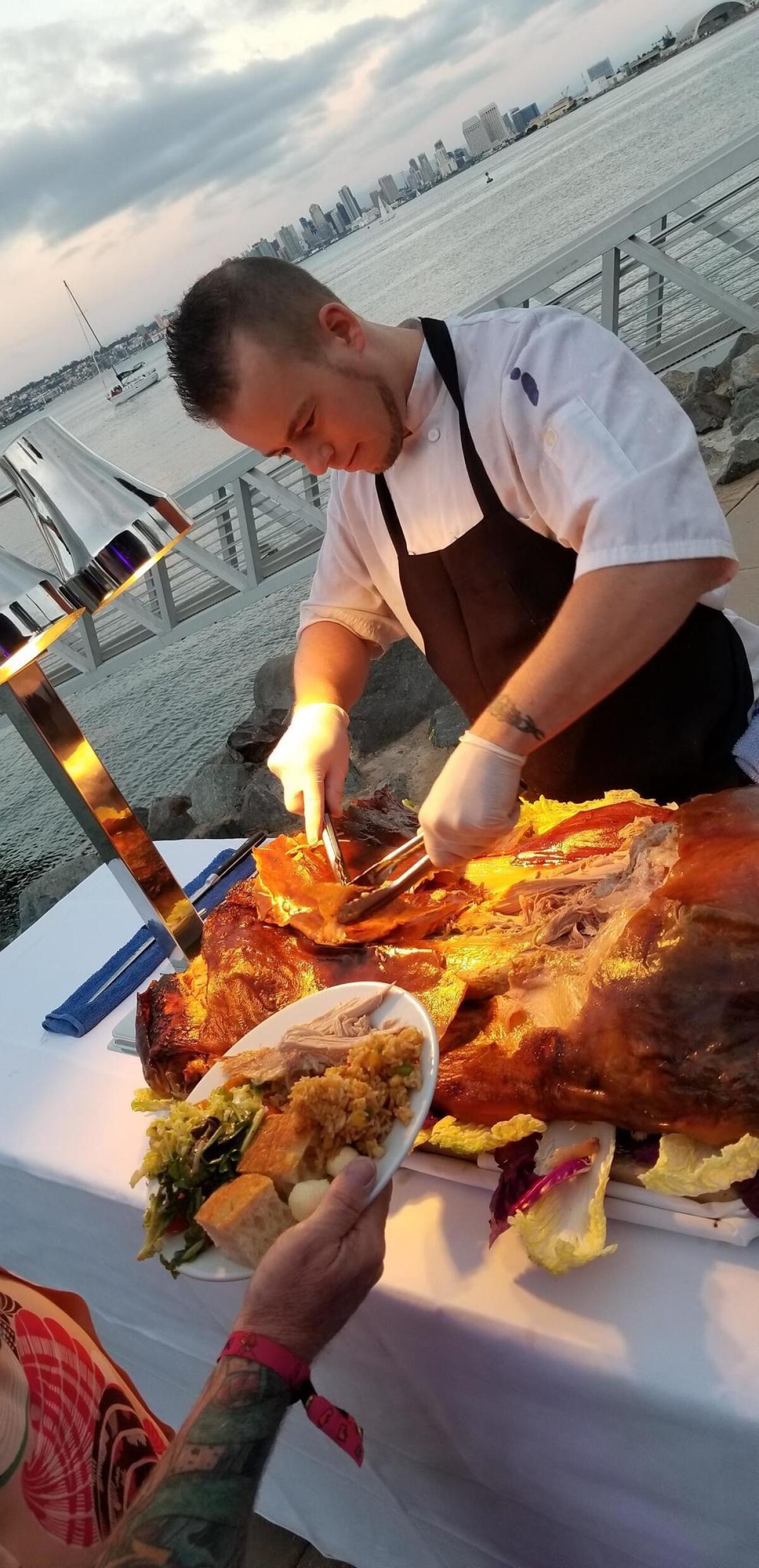 Kevin Oswald serves up roast pig, a luau treat.
