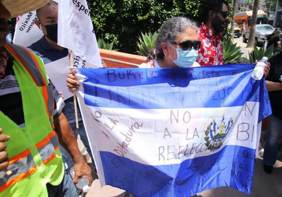 Entre los simpatizantes de AMLO, María Morales se introdujo con una bandera y un mensaje para el president de El Salvador.