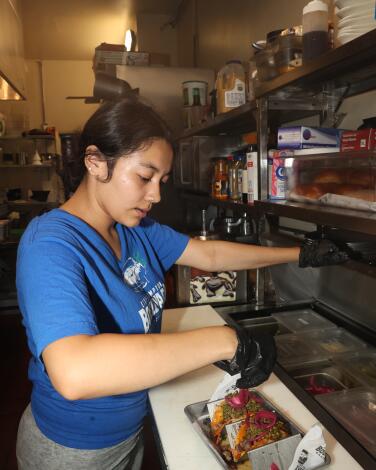 A chef sprinkles cilantro on tacos at Boulevard Gastropub 