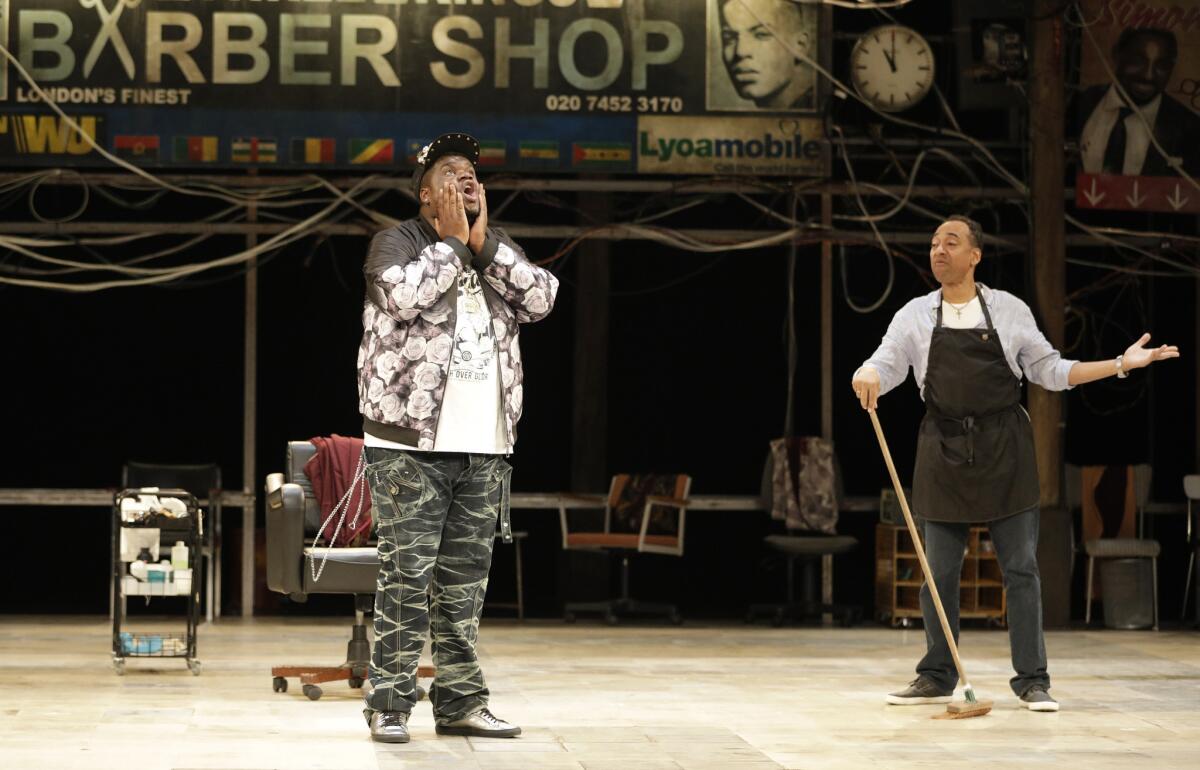 Tuwaine Barrett, left, shares a tale with Anthony Ofoegbu in "The Barber Shop Chronicles," playing at the Freud Playhouse at UCLA.