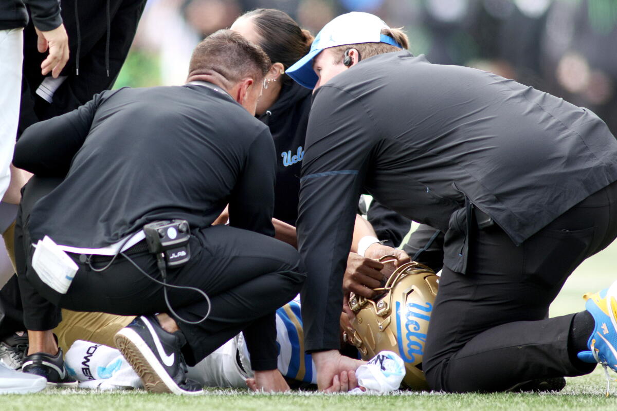 UCLA backmost Nico Iamaleava is examined by aesculapian unit while coach Bob Chesney watches Saturday successful Eugene, Ore.
