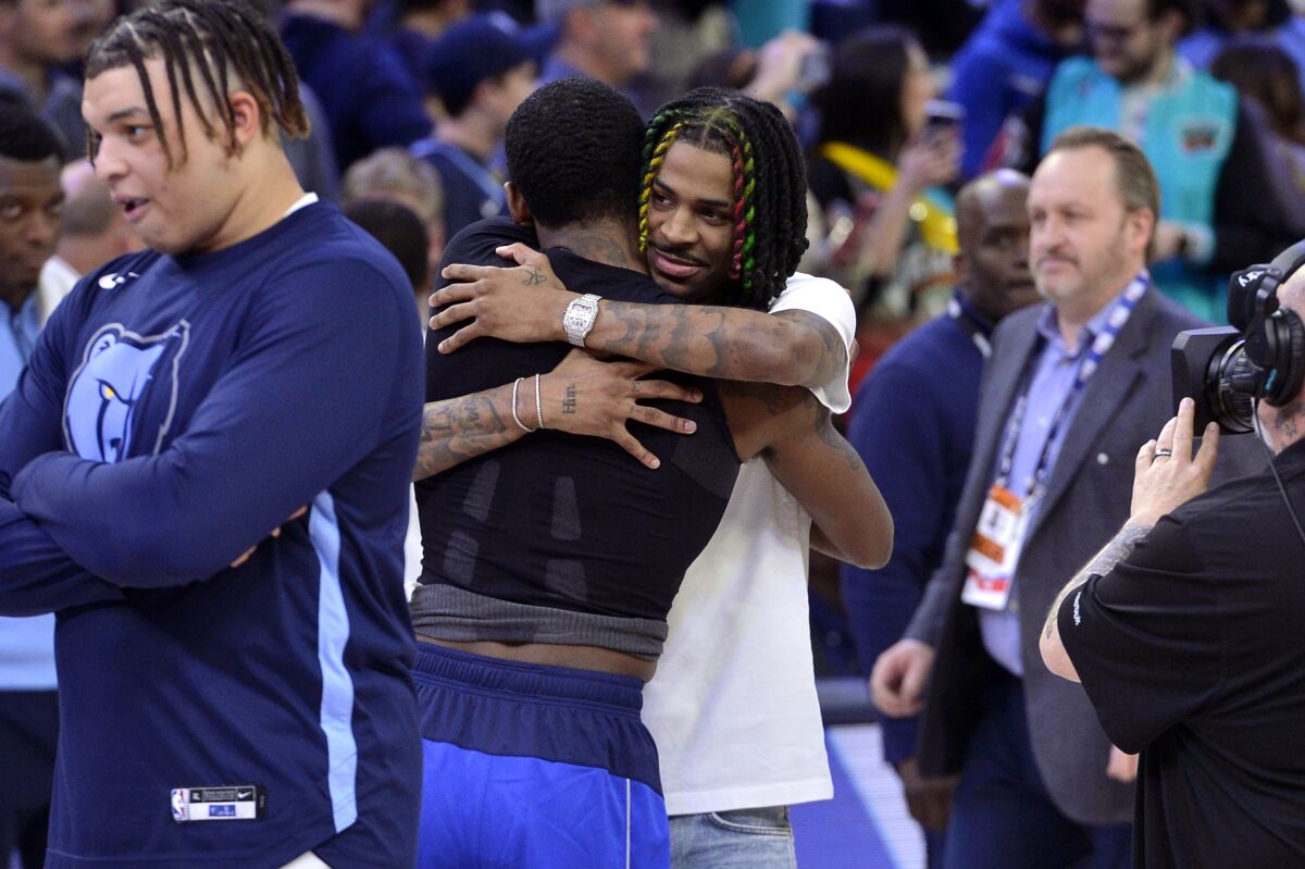 Memphis Grizzlies guard Ja Morant, center right, hugs Dallas Mavericks guard Kyrie Irving after an NBA basketball game Monday, March 20, 2023, in Memphis, Tenn. (AP Photo/Brandon Dill)