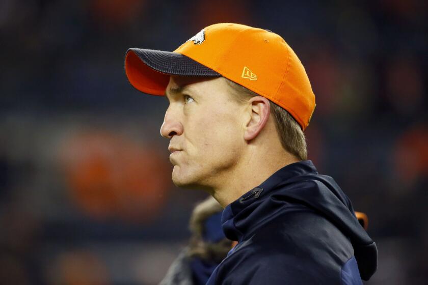 Broncos injured quarterback Peyton Manning looks on before a game against the Patriots.