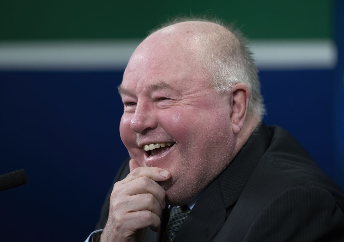 New Vancouver Canucks head coach Bruce Boudreau smiles as he attends an NHL hockey news conference in Vancouver, British Columbia, Monday, Dec. 6, 2021. (Jonathan Hayward/The Canadian Press via AP)