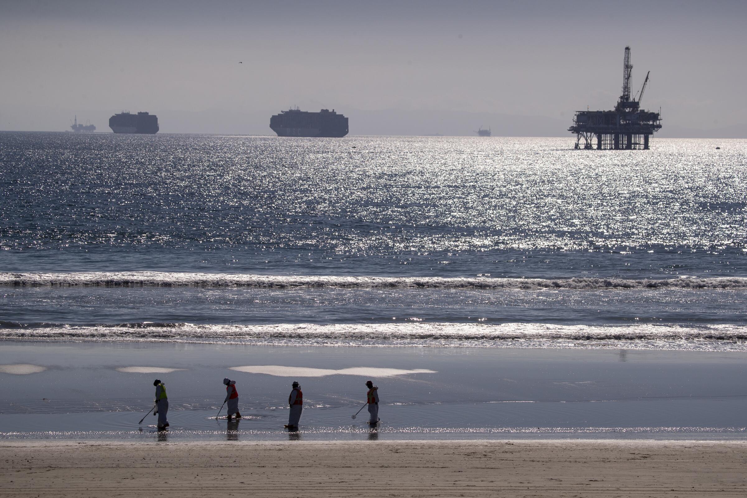 On the horizon, container ships and an oil derrick off Huntington Beach