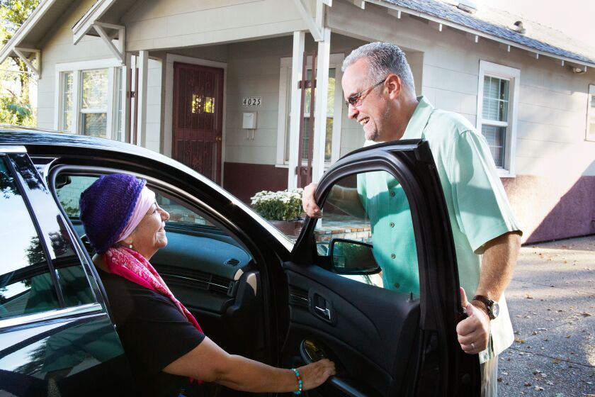 A volunteer driver with the American Cancer Society's Road To Recovery program gives a cancer patient a ride to treatment.