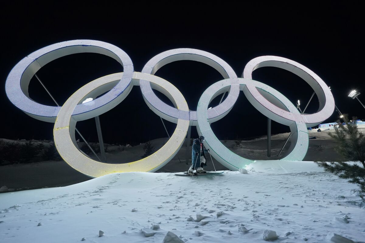 Switzerland's Marco Tade takes pictures by the Olympic rings during a training for the men's freestyle moguls skiing competition ahead of the 2022 Winter Olympics, Tuesday, Feb. 1, 2022, in Zhangjiakou, China. (AP Photo/Gregory Bull)