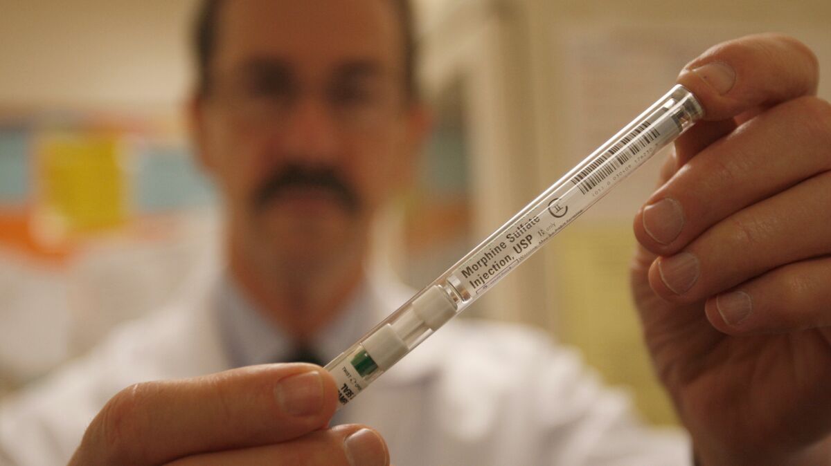 A doctor holds a syringe of morphine. Researchers have been trying to create a better version of the opioid drug that relieves pain without being addictive or putting patients at risk of respiratory distress.