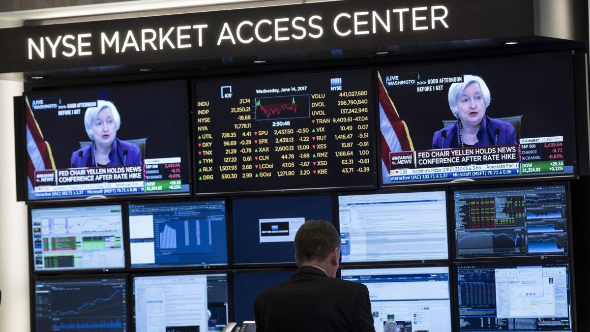 Traders work on the floor of the New York Stock Exchange as a television monitor displays Federal Reserve Chairwoman Janet Yellen announcing the Fed's decision to raise interest rates on June 14.