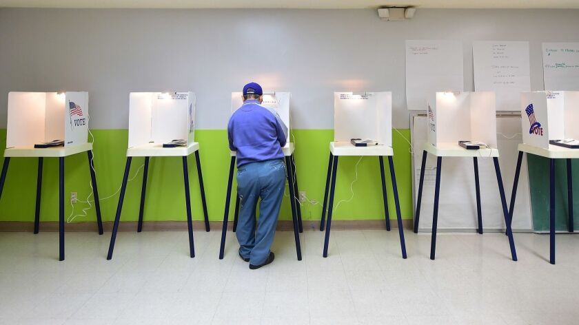 A voter casts his vote at a polling station in Pasadena on November 4, 2014.