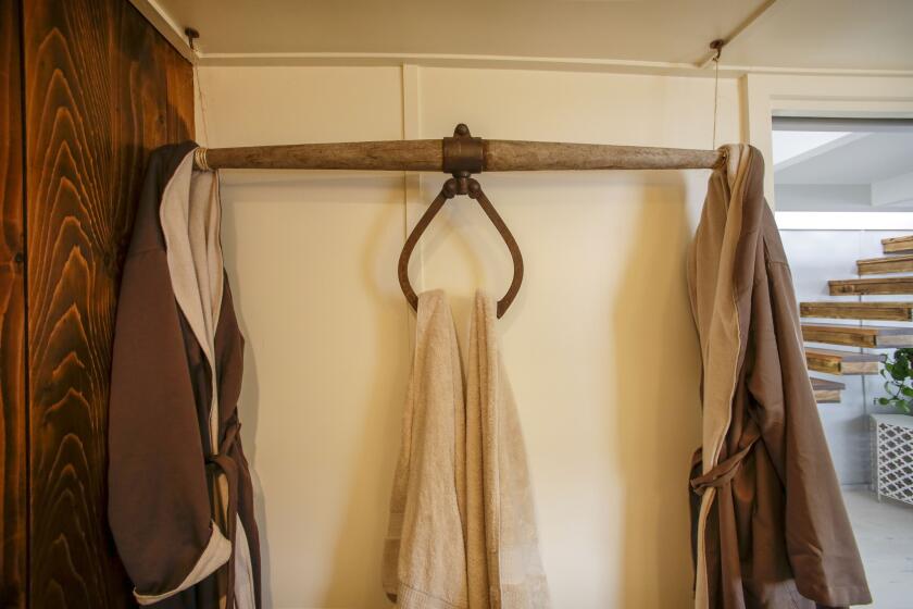 An ice hook deployed as a towel and robe rack in the bathroom.