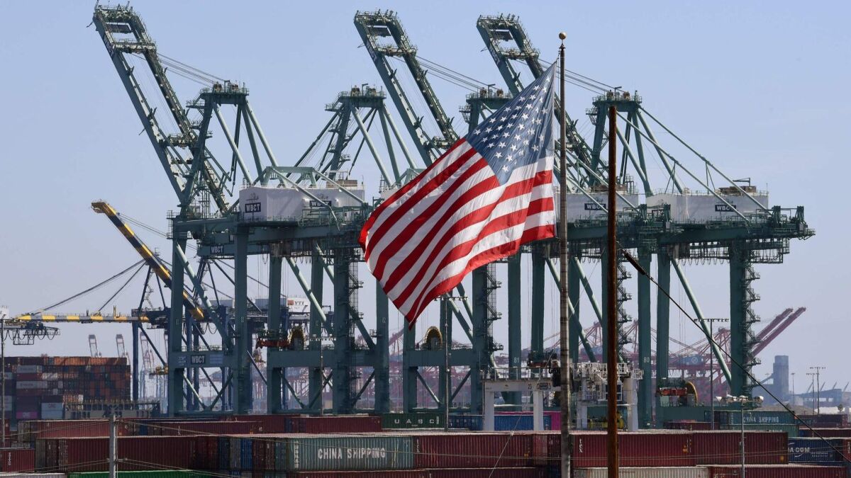 The U.S. flag flies over Chinese shipping containers unloaded at the Port of Long Beach.