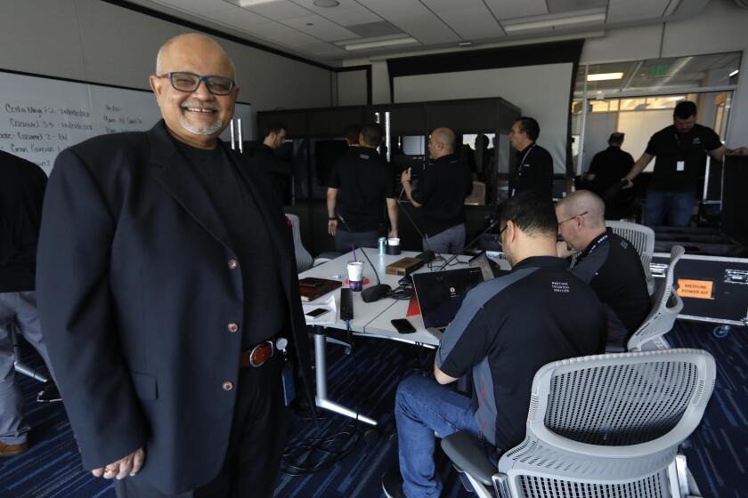 PLAYA VISTA, CA - MARCH 5, 2020 - Ashwin Rangan, Senior Vice President, Engineering and CIO, left, stands near members of ICANN Meetings Mechanical Services, who prepare the ICANN offices for a 3000-person call-in meeting after they cancelled a major conference in Cancun, Mexico, over fears of the coronavirus in Playa Vista on March 5, 2020. ICANN, which stands for Internet Corporation for Assigned Names and Numbers, is the agency that runs the Internet. They were retrofitting its offices and installing telecoms equipment for the event. (Genaro Molina / Los Angeles Times)