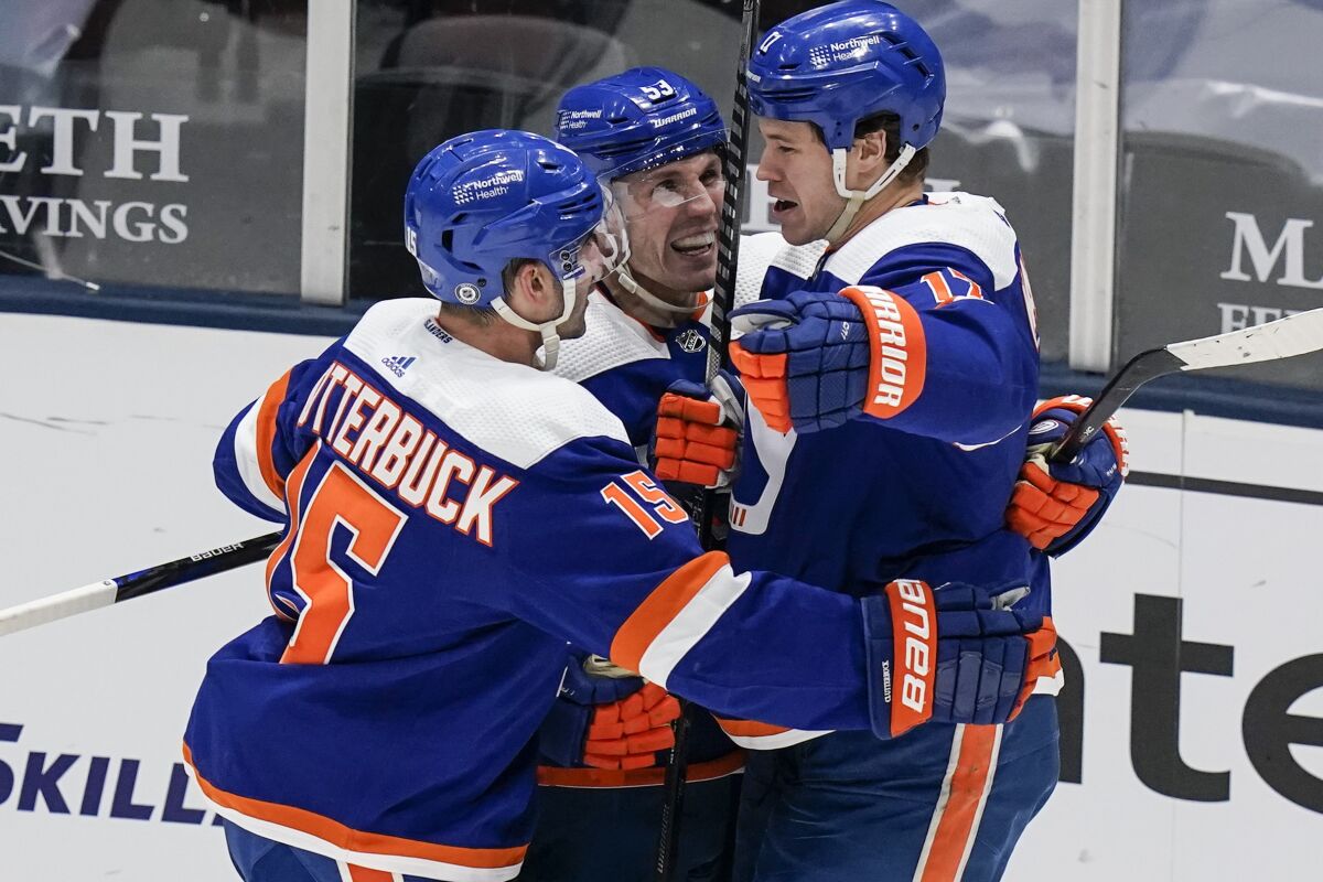 New York Islanders' Matt Martin, right, celebrates with teammates Casey Cizikas, center, and Cal Clutterbuck after scoring a goal during the third period of an NHL hockey game against the Buffalo Sabres Thursday, March 4, 2021, in Uniondale, N.Y. The Islanders won 5-2. (AP Photo/Frank Franklin II)