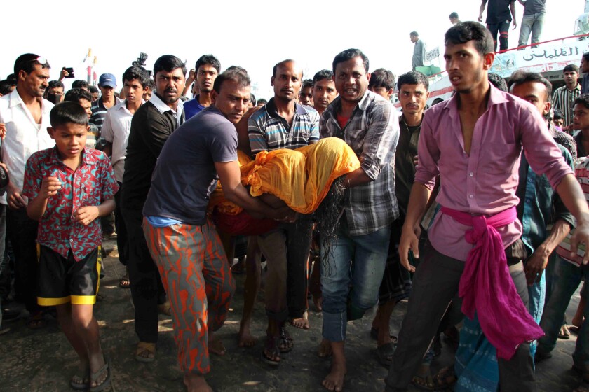 Bangladeshis carry the body of a ferry sinking victim at Manikganj, about 25 miles northwest of Dhaka.