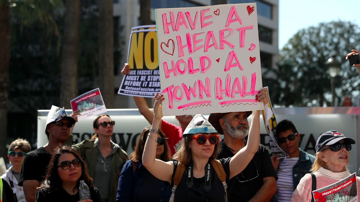 Protesters hold signs outside the Los Angeles office of California's U.S. Sen. Dianne Feinstein on Feb. 14 to demand she hold a town hall meeting.