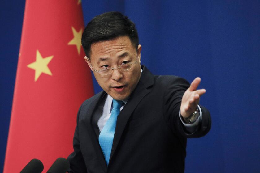 FILE - In this file photo taken Monday, Feb. 24, 2020, Chinese Foreign Ministry new spokesman Zhao Lijian gestures as he speaks during a daily briefing at the Ministry of Foreign Affairs office in Beijing. From Asia to Africa, London to Berlin, Chinese envoys have set off diplomatic firestorms with a combative defense whenever their country is accused of not acting quickly enough to stem the spread of the coronavirus pandemic. (AP Photo/Andy Wong, File)