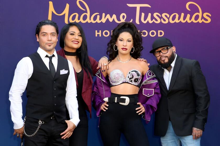 Chris Perez junto a la estatua de cera de Selena y sus cuñados Suzette y AB Quintanilla.