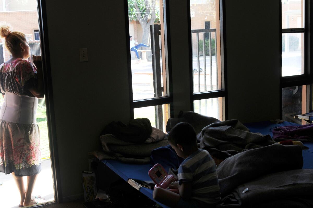 Fotografía de archivo donde aparece la inmigrante mirando desde la puerta de la habitación 