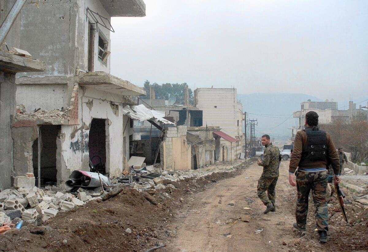 Syrian government forces patrol a street in the western town of Zara, near the Lebanese border, which had long been in rebel hands.
