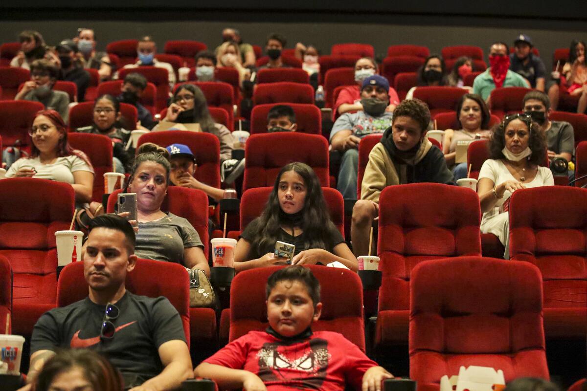 Moviegoers sit in red seats at an AMC theater in 2021. 