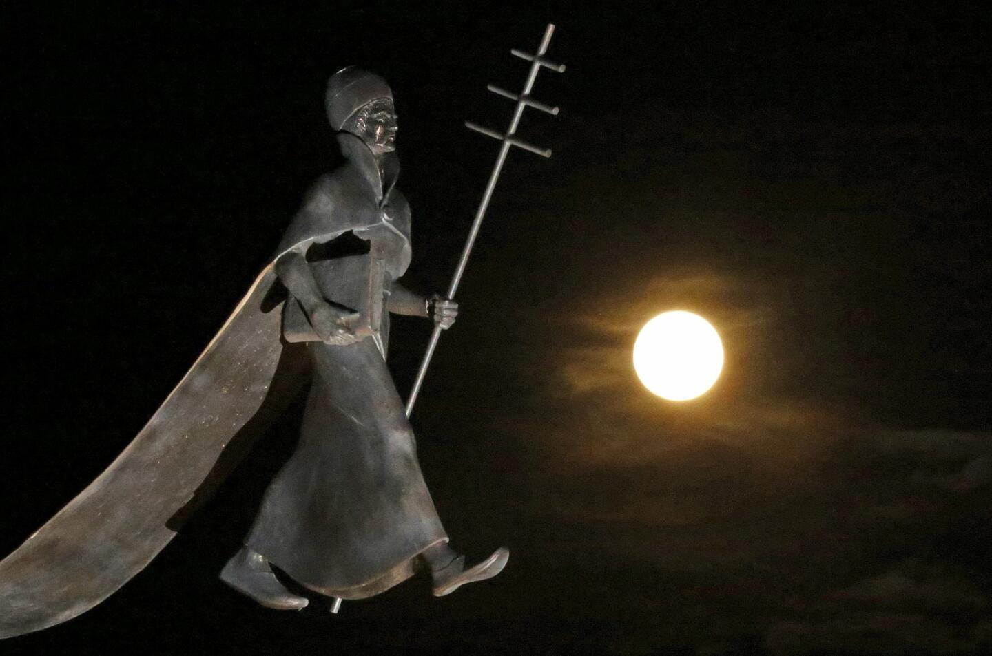 A full moon, the last of this year's supermoons, rises near a statue of Pope Leon IX in Eguisheim France.