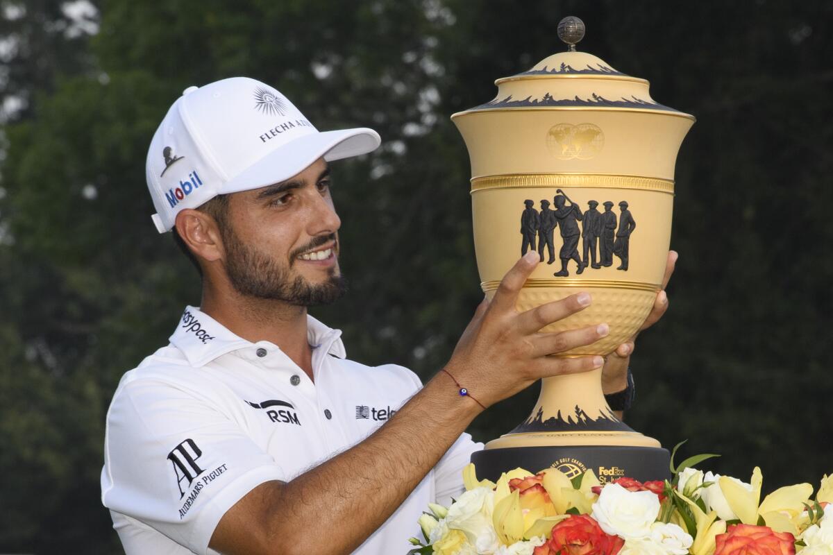 Abraham Ancer lifts the trophy after winning the World Golf Championship-FedEx St. Jude Invitational tournament on Sunday.
