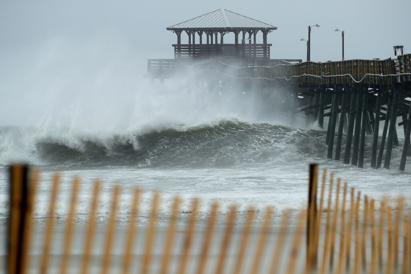 ATLANTIC BEACH, NC - SEPTEMBER 13: Waves crash underneath the Oceana Pier as the outer bands of Hurricane Florence being to affect the coast September 13, 2018 in Atlantic Beach, United States. Coastal cities in North Carolina, South Carolina and Virginia are under evacuation orders as the Category 2 hurricane approaches the United States.