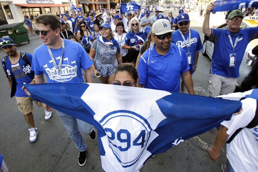 Pantone 294 Dodgers fan club members walk down Tony Gwynn Drive as they head for the gates of Petco Park.