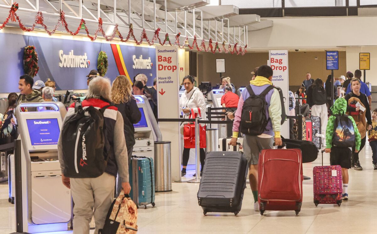 People check their bags and prepare to fly with Southwest Airlines at San Diego International Airport.