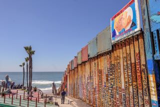 Biden y Trump se besan en pintura de protesta en muro fronterizo de México