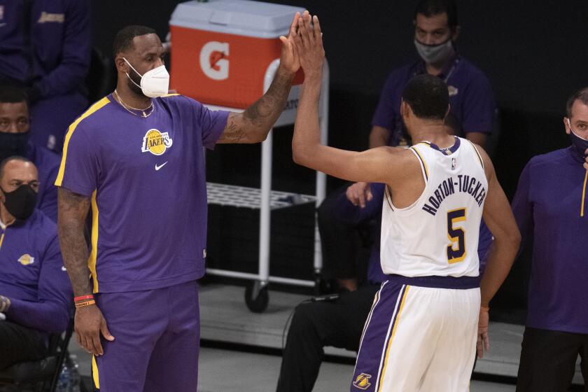 Los Angeles Lakers forward LeBron James, left, greets guard Talen Horton-Tucker.
