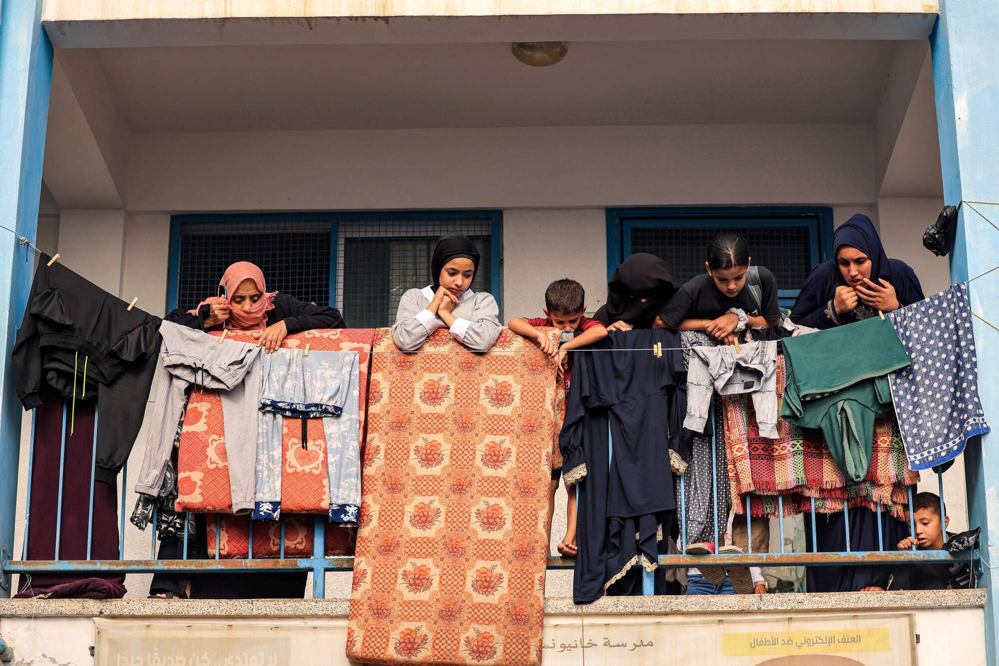 People stand on a balcony at a school run by the United Nations in Khan Yunis in the southern Gaza Strip.