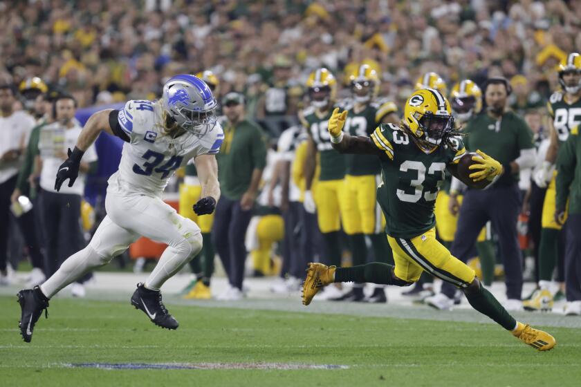 Green Bay Packers' Aaron Jones runs past Detroit Lions' Alex Anzalone during the first half of an NFL football game Monday, Sept. 20, 2021, in Green Bay, Wis. (AP Photo/Mike Roemer)