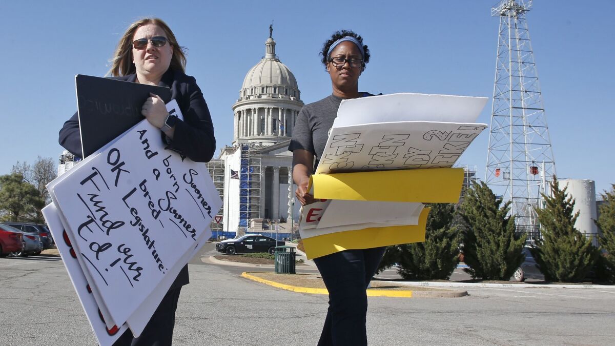 Kara Walk, left, assistant principal in the Putnam City School District of Oklahoma City and Ivana Beatty, assistant principal in the Oklahoma City Public Schools, gather protest signs.