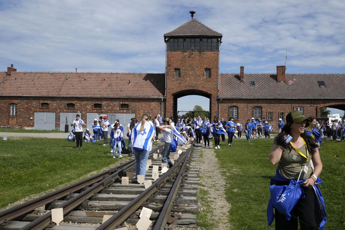People walk through the former Nazi concentration camp of Auschwitz-Birkenau.